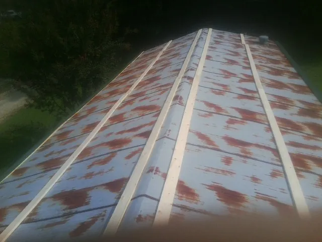 Rusted metal roof panels with new wood purlins before replacement — Storm Damage Roof Repair in Caruthers by Roofing Brothers