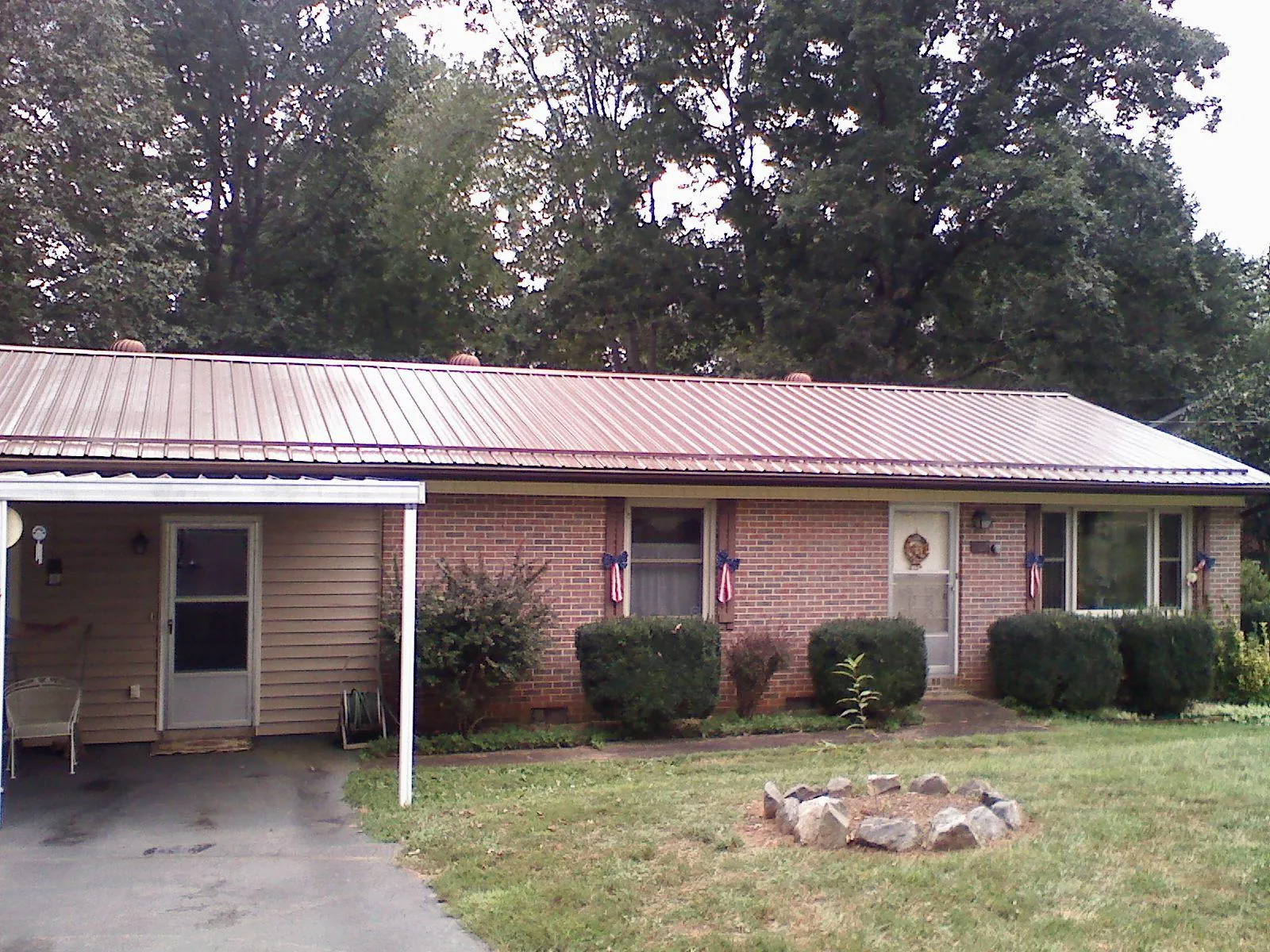 Bronze metal roof and carport on a brick ranch home — Roof Repair work by our crew in Caruthers